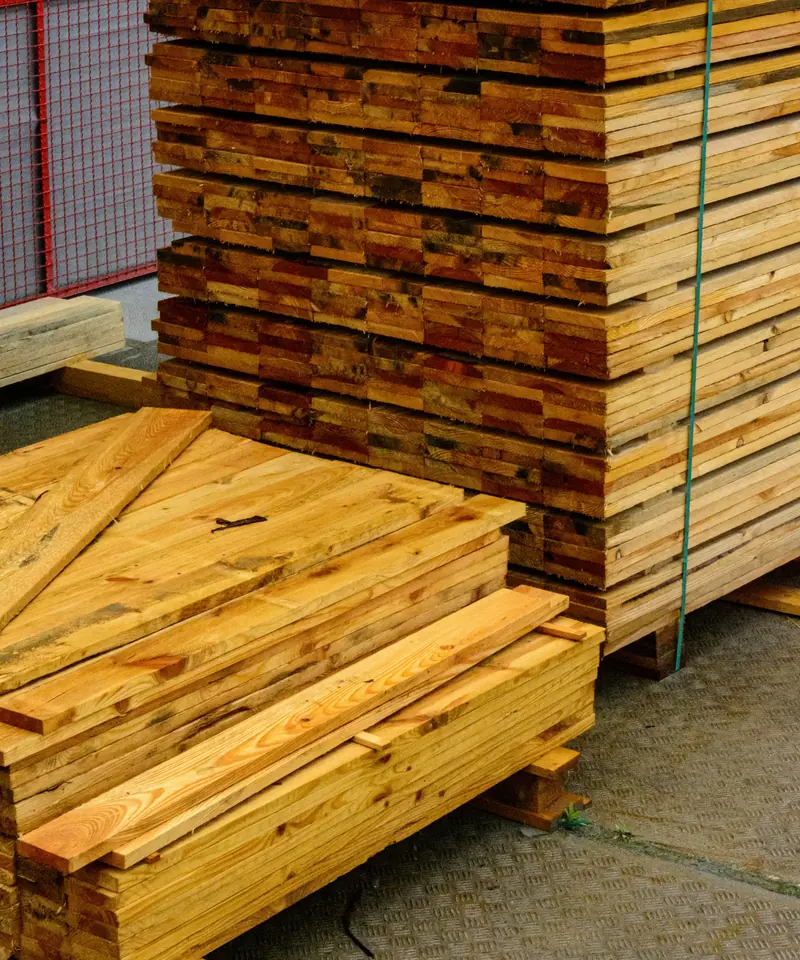 Stacks of new pressure-treated fence boards and lumber banded on pallets